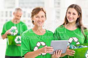 Smiling eco-minded women with tablet and recycling box