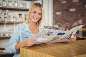 Smiling blonde holding newspaper