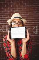 Beautiful hipster showing tablet to camera