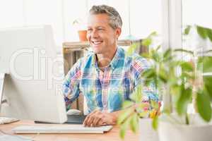 Smiling casual designer working with computer