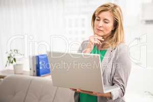 Concentrated casual businesswoman working with laptop