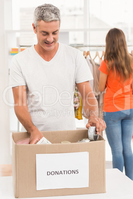 Smiling casual businessman sorting donations