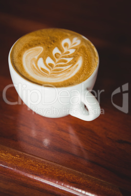 Cup of cappuccino with coffee art on the counter