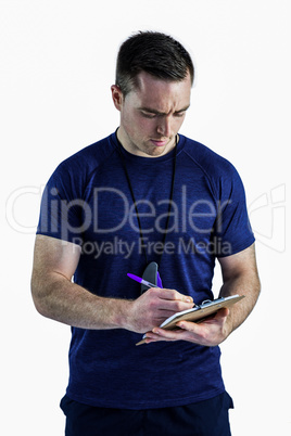 Attentive trainer writing on his clipboard