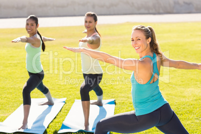 Yoga teacher and sporty women attending yoga class