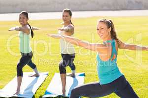 Yoga teacher and sporty women attending yoga class