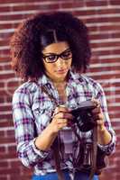 Attractive hipster looking at photos on camera