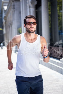 Handsome athlete with sunglasses jogging