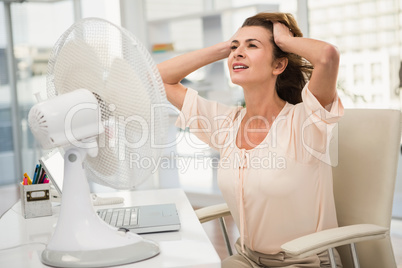 Casual businesswoman being cooled by ventilator