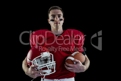 American football player holding helmet