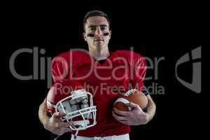 American football player holding helmet