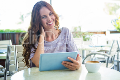 Woman using tablet on cafe terrace