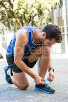 Handsome athlete tying his shoes