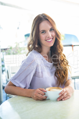 Pretty brunette enjoying a cappuccino