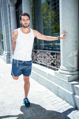 Handsome athlete doing leg stretching