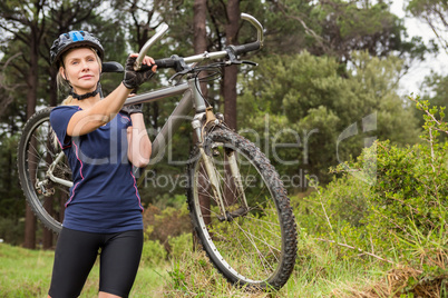 Athletic blonde carrying her mountain bike