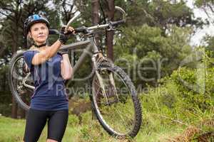 Athletic blonde carrying her mountain bike