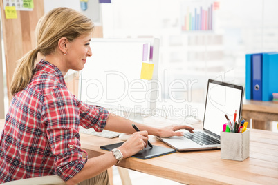 Casual designer working with digitizer and laptop