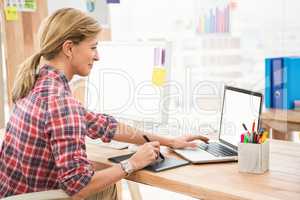 Casual designer working with digitizer and laptop