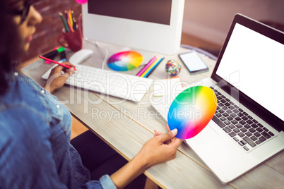 Casual female designer looking at colour chart