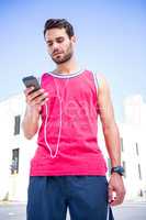 Handsome athlete sending a text