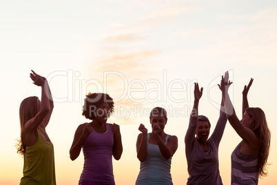 Happy sporty women cheering against sunset