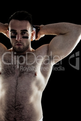 Shirtless American football player with ball