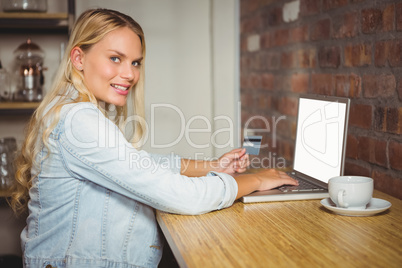 Smiling blonde doing online shopping