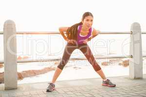 Fit woman stretching at promenade