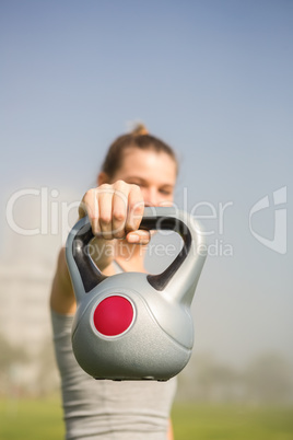 Sporty blonde lifting kettlebell