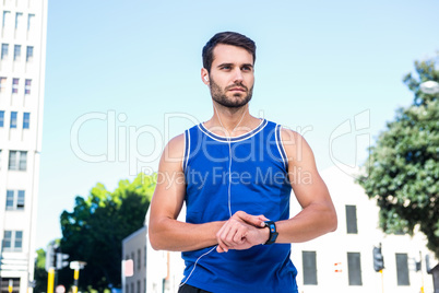 Handsome athlete setting heart rate watch