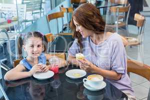 Mother and daughter enjoying cakes