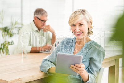 Smiling businesswoman working on a tablet