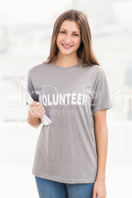 Smiling brunette volunteer holding sheets
