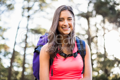 Young happy jogger sitting on rock and looking at camera