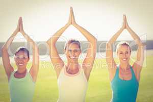 Smiling sporty women doing yoga together