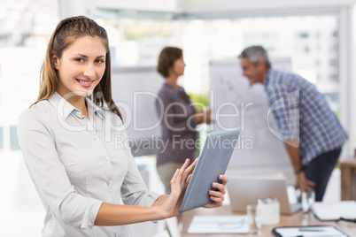 Smiling businesswoman with tablet in a meeting