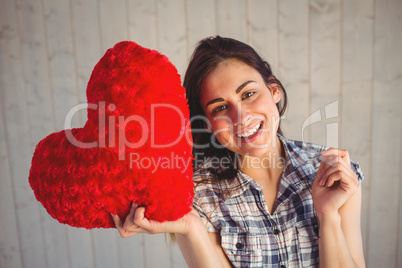 Pretty hipster holding heart pillow