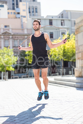 Handsome athlete doing jumping rope