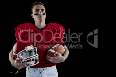 American football player holding helmet
