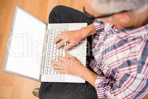 Casual man sitting and working with laptop