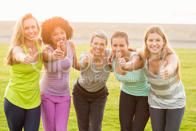 Smiling sporty women doing thumbs up