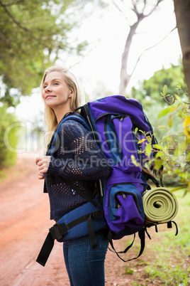 Smiling female hiker waiting by the side of the road