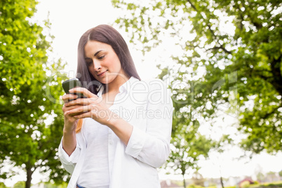 Beautiful brunette sending a text message