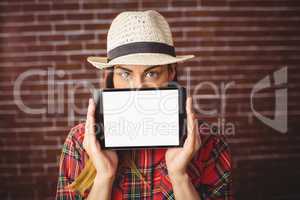 Beautiful hipster showing tablet to camera
