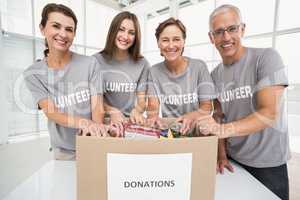 Smiling volunteers sorting donation box