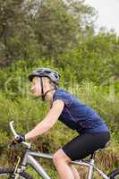 Smiling athletic blonde mountain biking