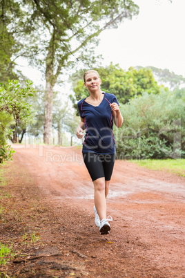 Athletic woman running on a footpath