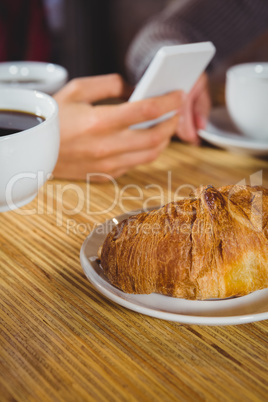 Close up view of cups of coffee and croissant