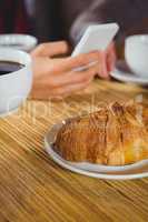 Close up view of cups of coffee and croissant
